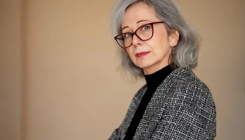 Eine Frau über 60 mit Brille und einer schmeichelhaften Frisur