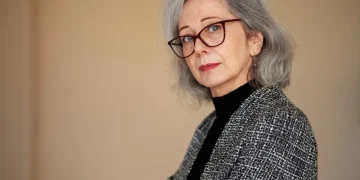 Eine Frau über 60 mit Brille und einer schmeichelhaften Frisur