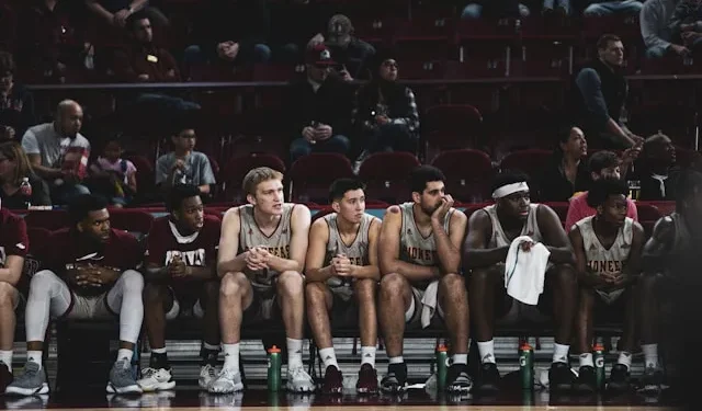 Ein Foto von LOGAN WEAVER | @LGNWVR auf Unsplash zeigt eine Gruppe von Basketballspielern auf der Bank