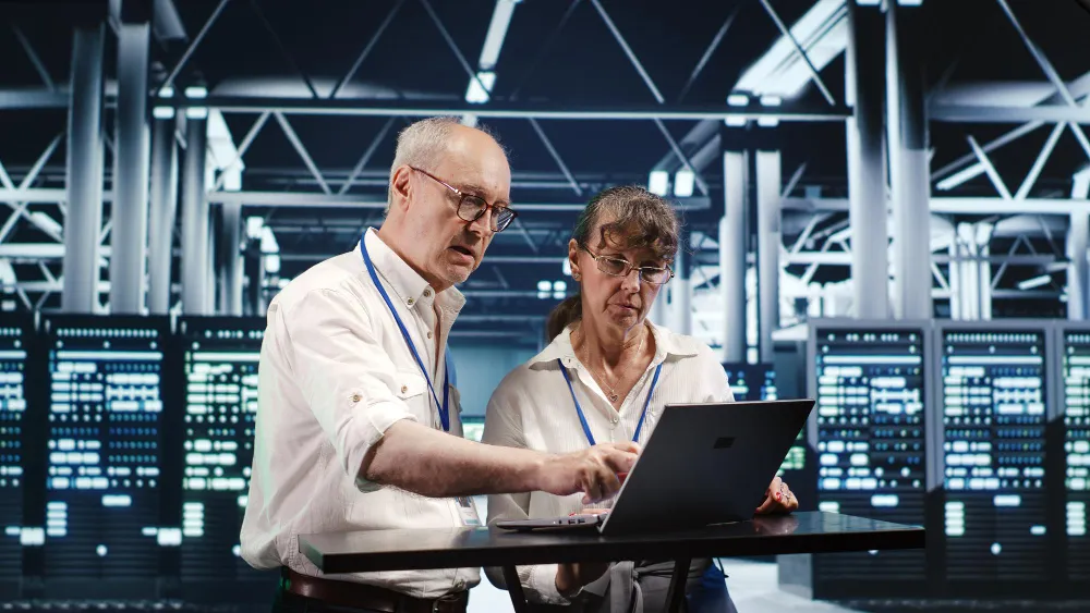 Zwei Fachinformatiker für Systemintegration analysieren Serverdaten und Netzwerke in einem modernen Rechenzentrum