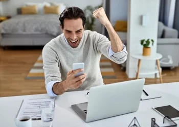 Mann freut sich über erfolgreichen Online-Geschäftsabschluss