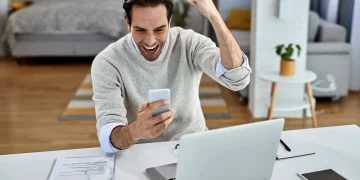 Mann freut sich über erfolgreichen Online-Geschäftsabschluss