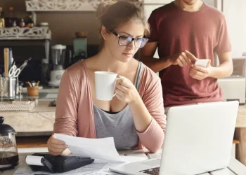 Selbstständige prüft Unterlagen für Kredit für Selbstständige am Laptop