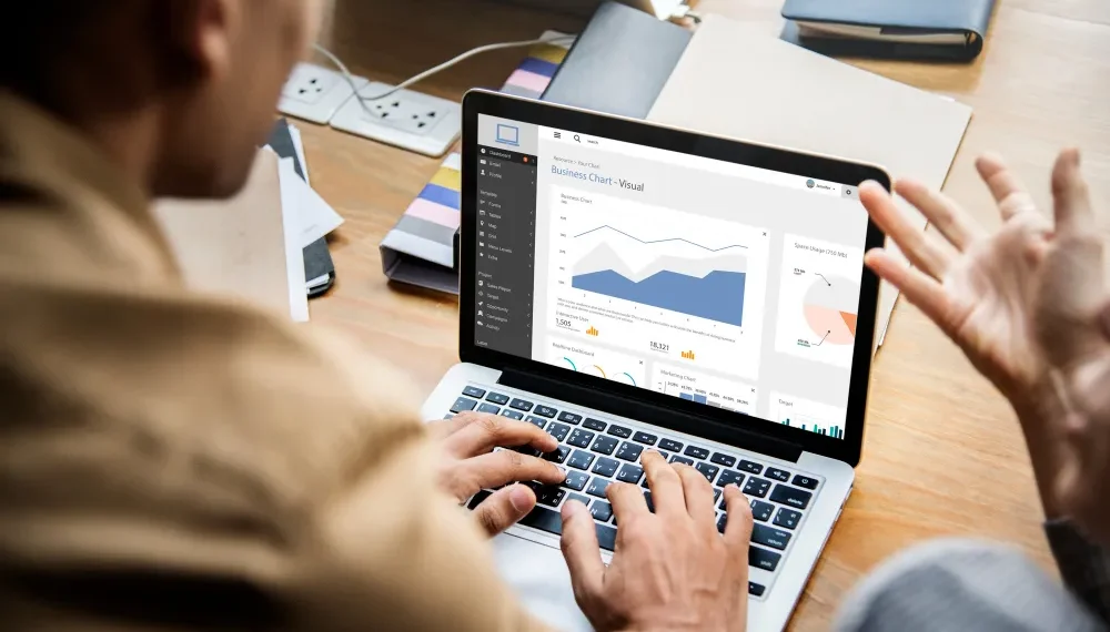 Mann arbeitet an Laptop mit Dynamics 365 auf dem Bildschirm