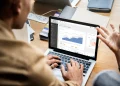 Mann arbeitet an Laptop mit Dynamics 365 auf dem Bildschirm