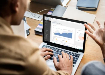 Mann arbeitet an Laptop mit Dynamics 365 auf dem Bildschirm