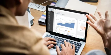 Mann arbeitet an Laptop mit Dynamics 365 auf dem Bildschirm