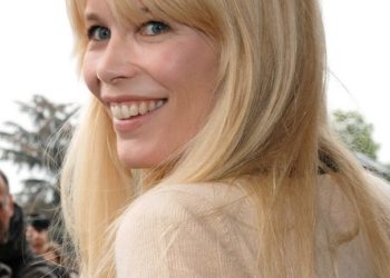 Claudia Schiffer (2009) lächelnd im Halbprofil mit blondem, offenem Haar bei der Chanel-Show im Grand Palais in Paris.