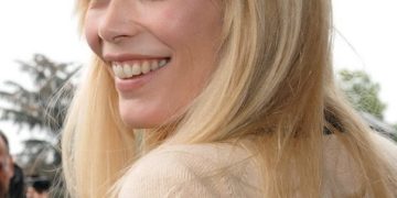 Claudia Schiffer (2009) lächelnd im Halbprofil mit blondem, offenem Haar bei der Chanel-Show im Grand Palais in Paris.