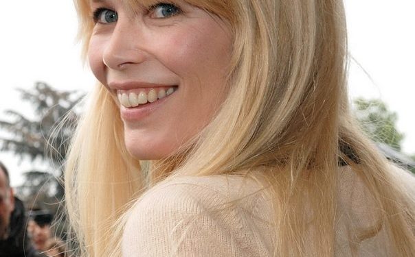 Claudia Schiffer (2009) lächelnd im Halbprofil mit blondem, offenem Haar bei der Chanel-Show im Grand Palais in Paris.