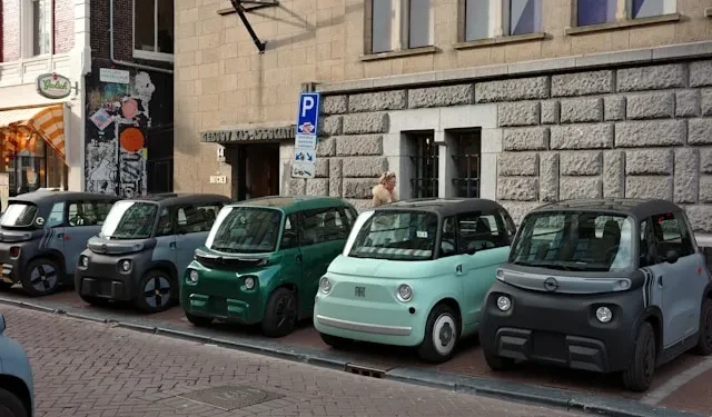 Mehrere Microcars und Mopedautos am Straßenrand